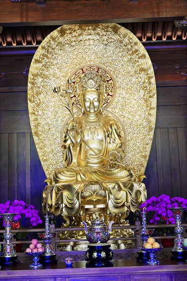 Jade Buddha Temple, Shanghai, Golden Buddha statue on an altar surrounded by pretty flowers,