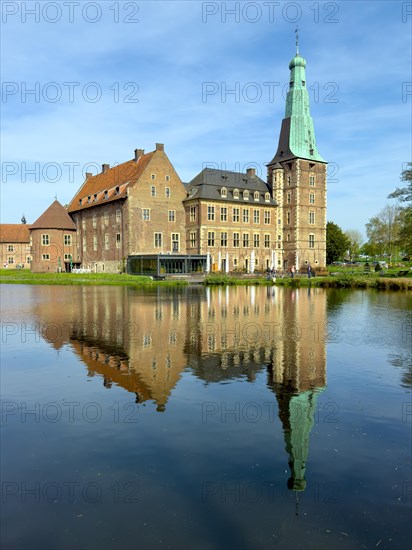 View over moat to historic moated castle from Renaissance Raesfeld Castle reflected in moat in