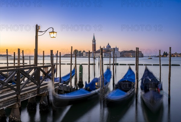 Venetian gondolas, boat dock at St Mark's Square, church of San Giorgio Maggiore in the background,