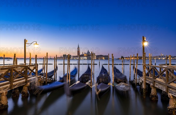 Venetian gondolas, boat dock at St Mark's Square, church of San Giorgio Maggiore in the background,