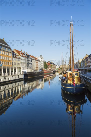 Moored Liva II restaurant boat, ships and colourful 17th century apartment buildings and houses