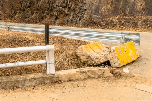 End buttress of street curb broken off and laying on ground at intersection in countryside in South