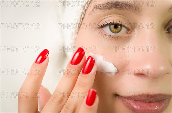 Hydration. Cream smear. Beuaty close up portrait of young woman with a healthy glowing skin is
