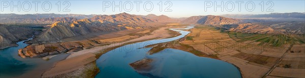 Naryn River between mountains and fields, at Toktogul Reservoir at sunset, aerial view, Kyrgyzstan,