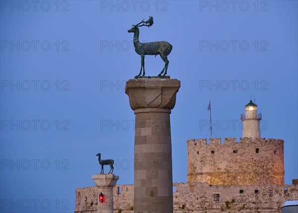 Deer statue on a pillar in front of a fortress wall and a lighthouse at dusk, Deer statue, Deer