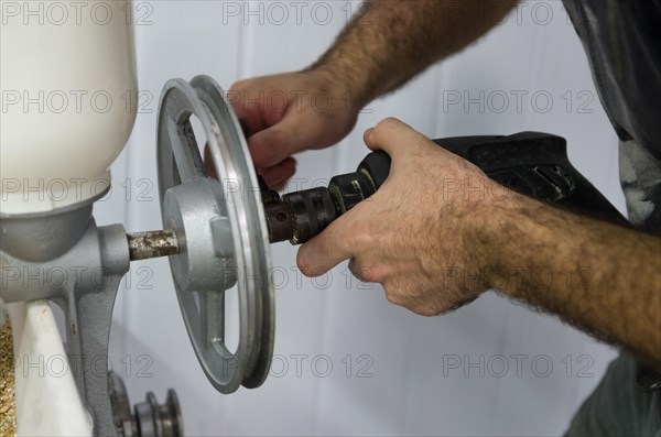 Homebrewer setting up a malt mill to grind with the aid of a drill