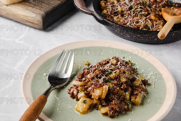 Risotto with pink rice, pear and blue cheese served on a table