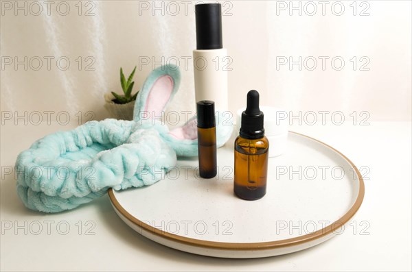 Cosmetic packaging. Set of different cosmetics on plate with decoration and bunny headband