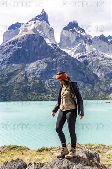 Young woman in front of Nordenskjold Lake and the Paine Mountain Range, Torres de Paine, Magallanes