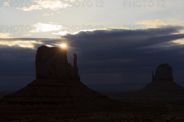 The last light of the sun shines from behind a rock needle and creates a mystical atmosphere,