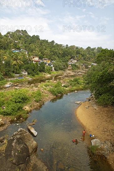 Indian people washing clothes in the Periyar River, Mundakayam, Kerala, India, Asia