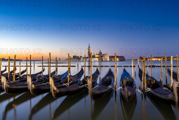 Venetian gondolas, boat dock at St Mark's Square, church of San Giorgio Maggiore in the background,