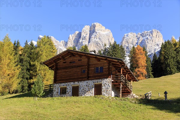 Rustic alpine hut against a backdrop of rugged mountains in autumn, Italy, Alto Adige, Bolzano