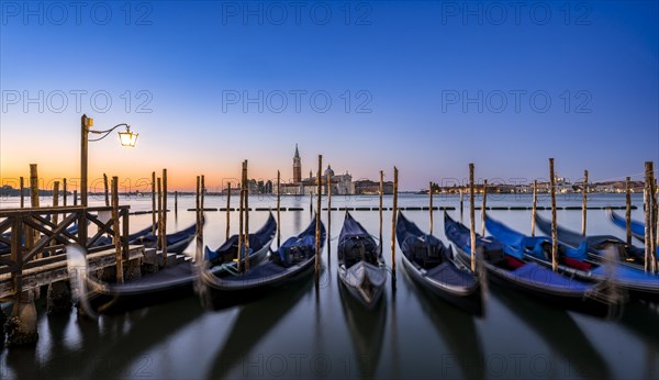Venetian gondolas, boat dock at St Mark's Square, church of San Giorgio Maggiore in the background,