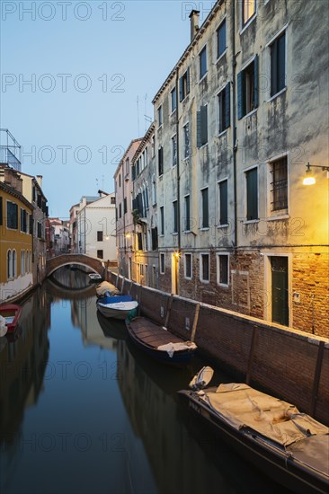Moored boats and footbridge over Rio de la Toletta Canal with old architectural style residential
