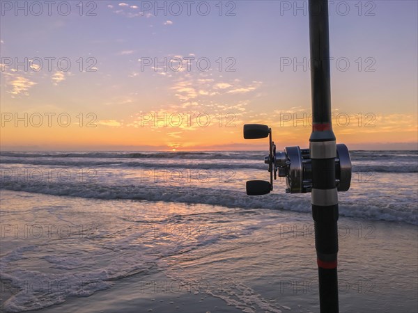Fishing rod on beach at sunset, surfing cast
