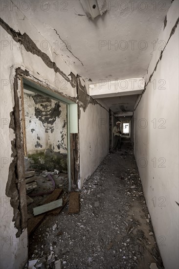 Tourist with camera in an abandoned ruined corridor, ghost town, Engilchek, Tian Shan, Kyrgyzstan,