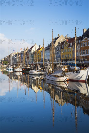 Moored sailboats and colourful 17th century apartment buildings and houses along the Nyhavn canal,
