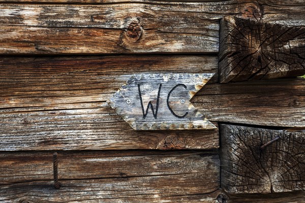WC sign on the wooden wall of the Naturalpe Gemstel-Schoenesboden-Alpe, Gemsteltal, Mittelberg,