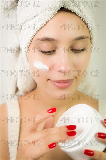 Hydration. Cream smear. Beuaty close up portrait of young woman with a healthy glowing skin is