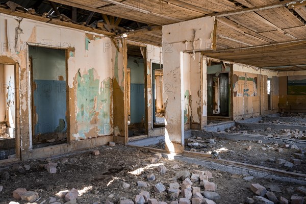 Destroyed abandoned classroom of the old school, wall painting with Soviet miners, ghost town,