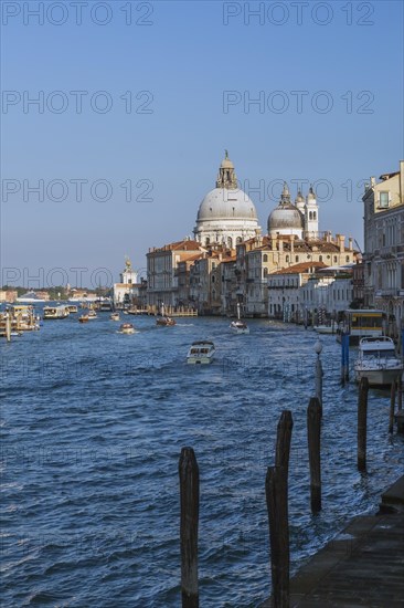 Grand Canal with water taxis, vaporettos and Santa Maria della Salute basilica in Dorsoduro