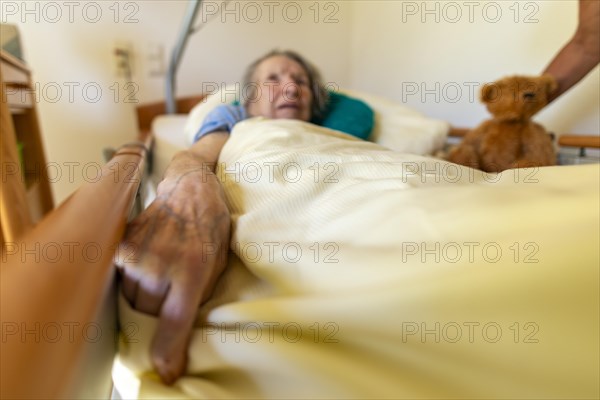 Senior citizen with dementia lying in her room in a retirement home, portrait, Baden-Wuerttemberg,