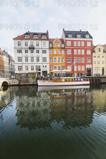 Moored boat and colourful 17th century apartment buildings and houses along the Nyhavn canal,
