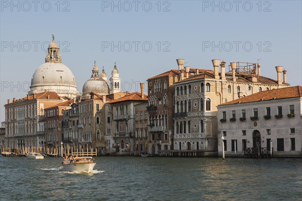 Water taxi on Grand Canal with Renaissance architectural style palace buildings and Santa Maria