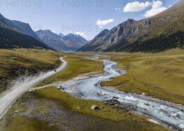 Car on road, mountain river in green mountain valley in the Tien Shan Mountains, Jety Oguz,