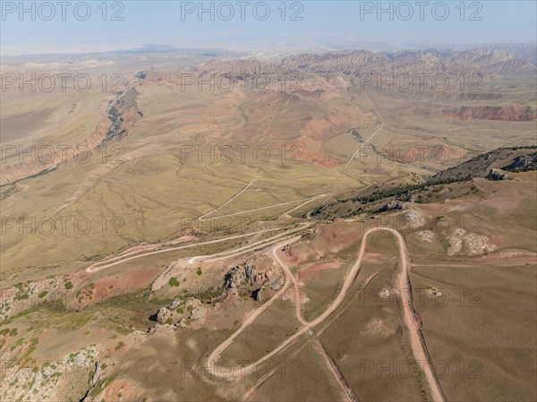 Moldo-Ashuu Pass, serpentines, car on road between yellow hills, near Baetov, Naryn region,