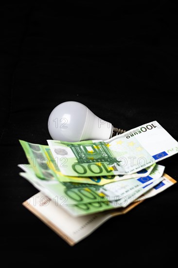 Electric light bulb on money and coins Finance and saving electricity. Concept of saving light and