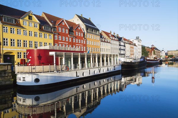 Moored Liva II restaurant boat, ships and colourful 17th century apartment buildings and houses