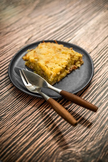 Plate with meat and grated potato pie on ceramic plate on rustic table