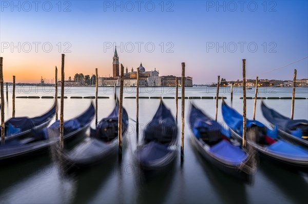 Venetian gondolas, boat dock at St Mark's Square, church of San Giorgio Maggiore in the background,