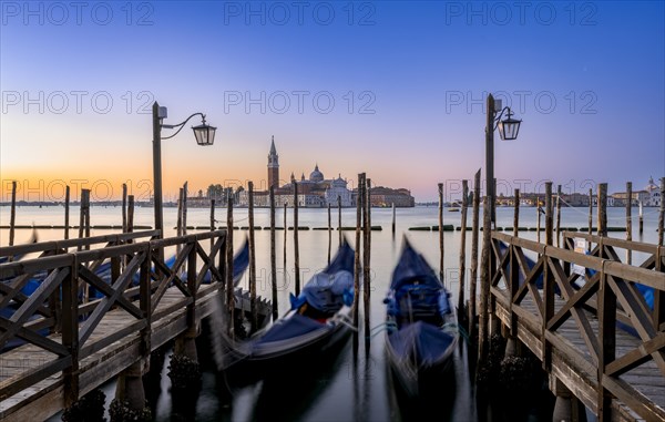 Venetian gondolas, boat dock at St Mark's Square, church of San Giorgio Maggiore in the background,