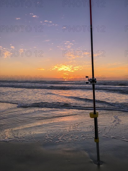 Fishing rod on beach at sunset, surfing cast