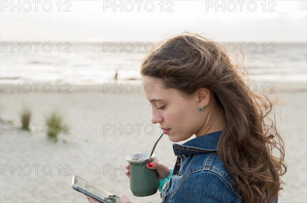 Beautiful young woman drinking Chimarao, mate tea tea (yerba mate tea tea infusion drink) on the