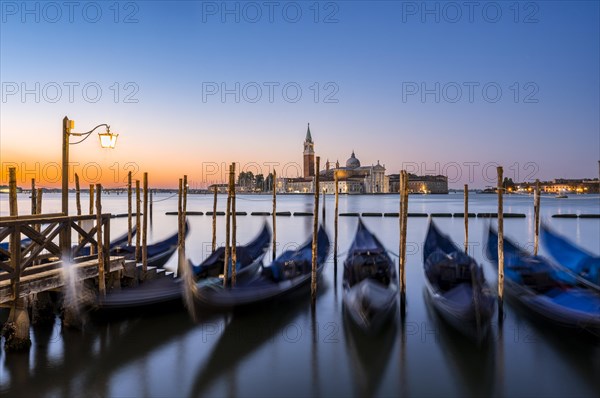Venetian gondolas, boat dock at St Mark's Square, church of San Giorgio Maggiore in the background,