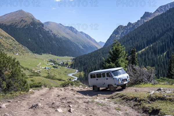 UAZ Buchanka, Russian off-road vehicle on 4x4 track, green mountain valley with village Altyn