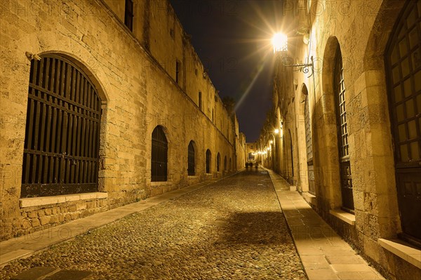 An old cobbled street at night, illuminated by street lamps creating a warm atmosphere, Knights