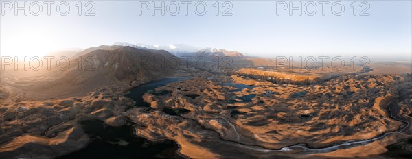 Atmospheric aerial view, high mountain landscape with glacier moraines and mountain lakes, behind