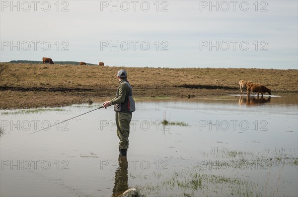 Sport fisherman fishing in lake on cloudy day, Cambara do sul, Rio Grande do sul, Brazil, South
