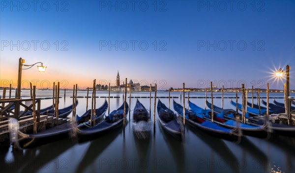 Venetian gondolas, boat dock at St Mark's Square, church of San Giorgio Maggiore in the background,