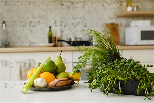 Fresh vegetables, herbs and fruits on a kitchen table