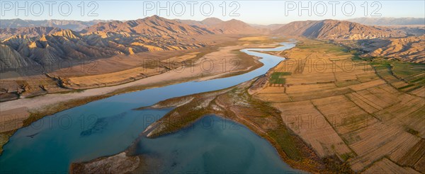 Naryn River between mountains and fields, at Toktogul Reservoir at sunset, aerial view, Kyrgyzstan,