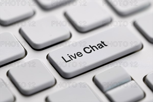 Close up of live chat key on white keyboard. Close up of wind mill turbine covered in ic ein