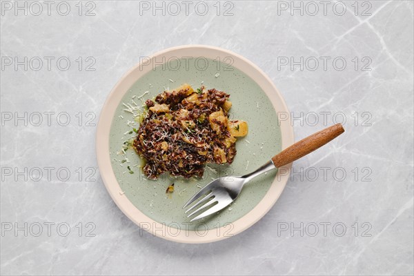 Plate with risotto with pink rice, pear and blue cheese on a table