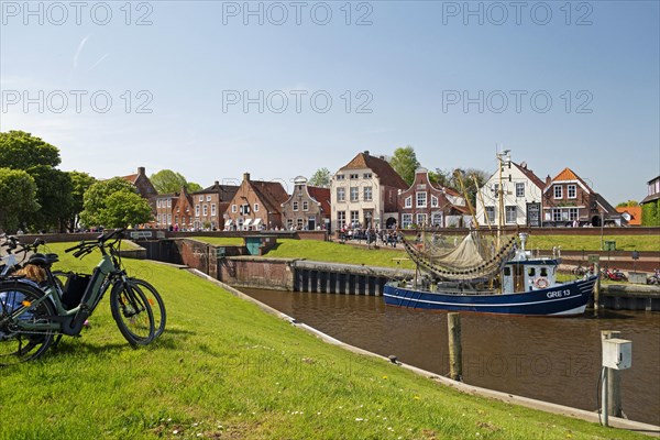 Picturesque cutter harbour, Greetsiel, ebikes, gabled houses, Krummhoern, East Frisia, Germany,