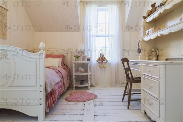 Single bed with red, pink and grey tartan bedspread, white painted antique style wooden headboard